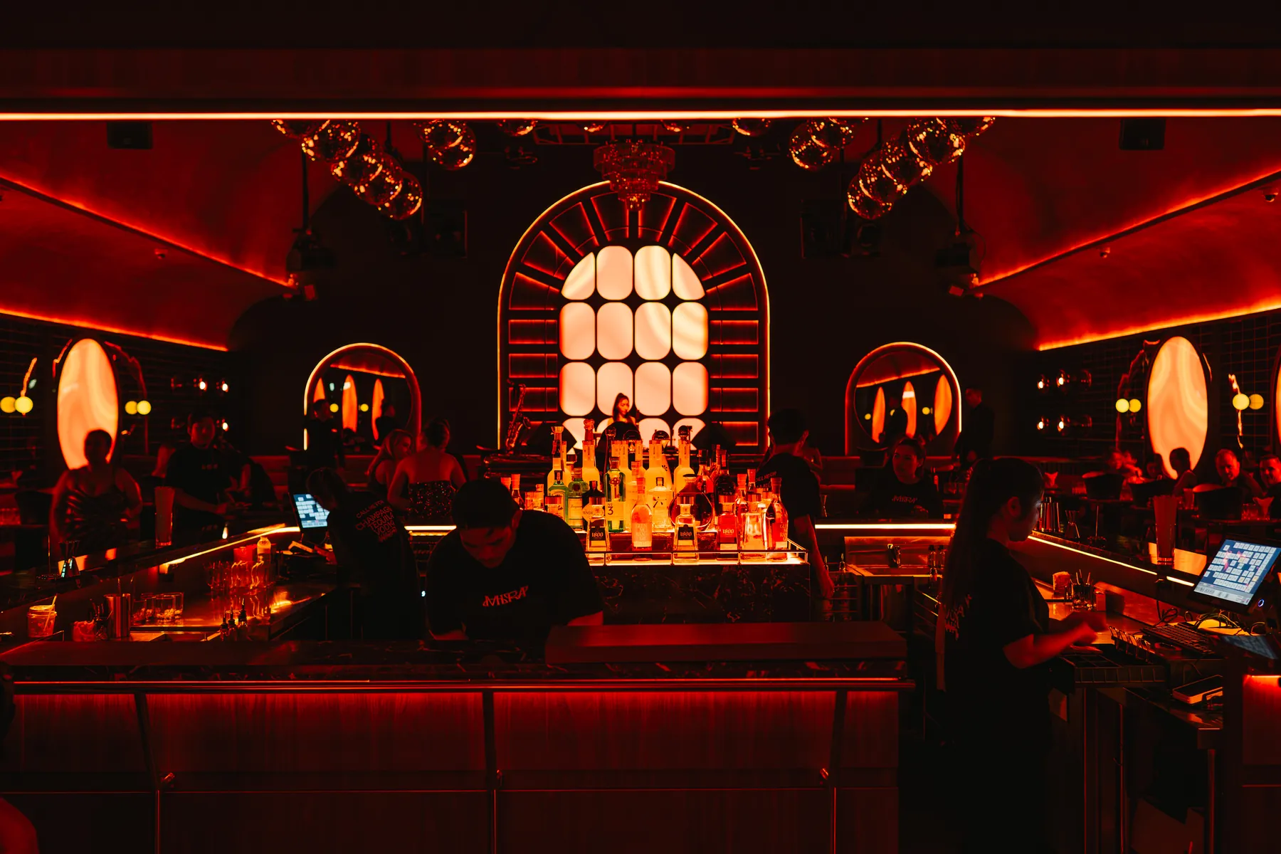 The bar at MIRA Club Bangkok, bottles under red light