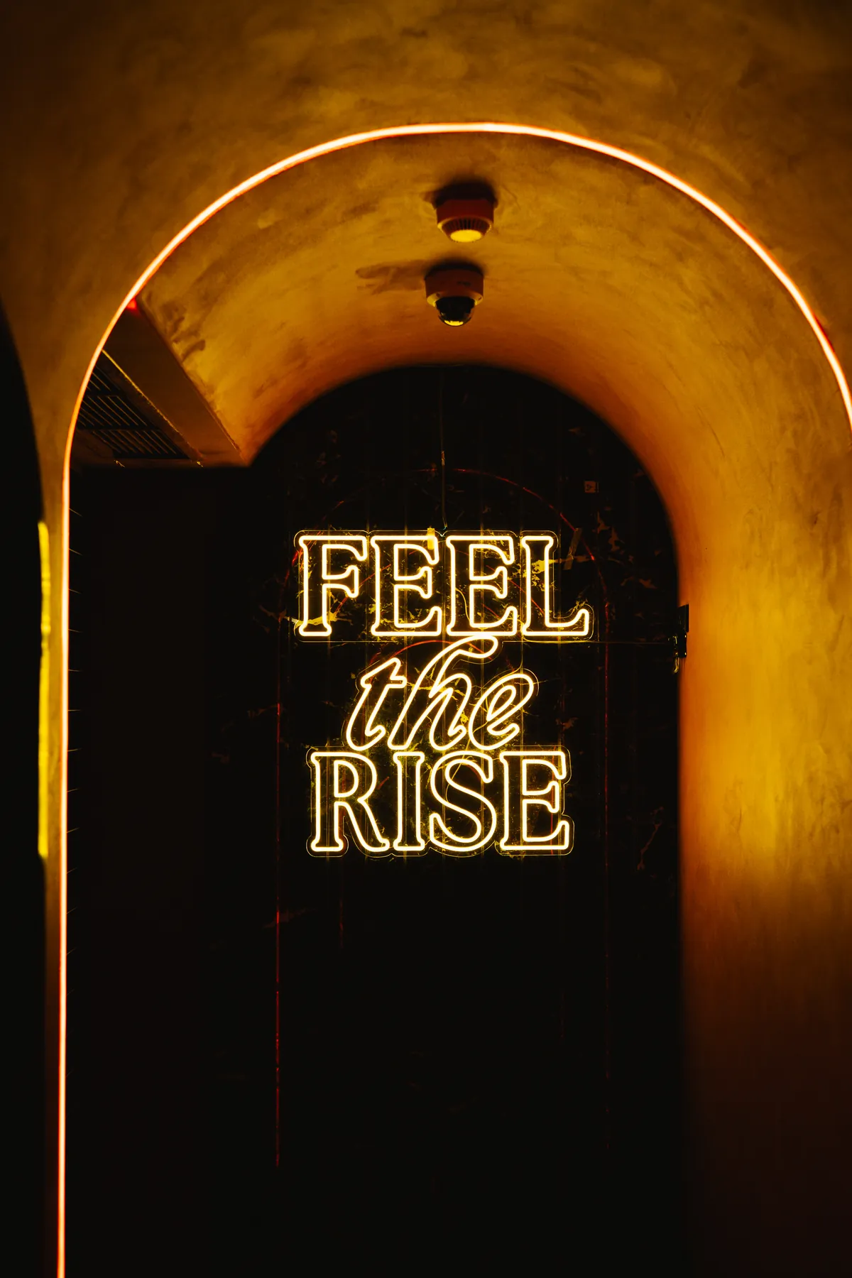 The illuminated arch and Feel the Rise neon at MIRA