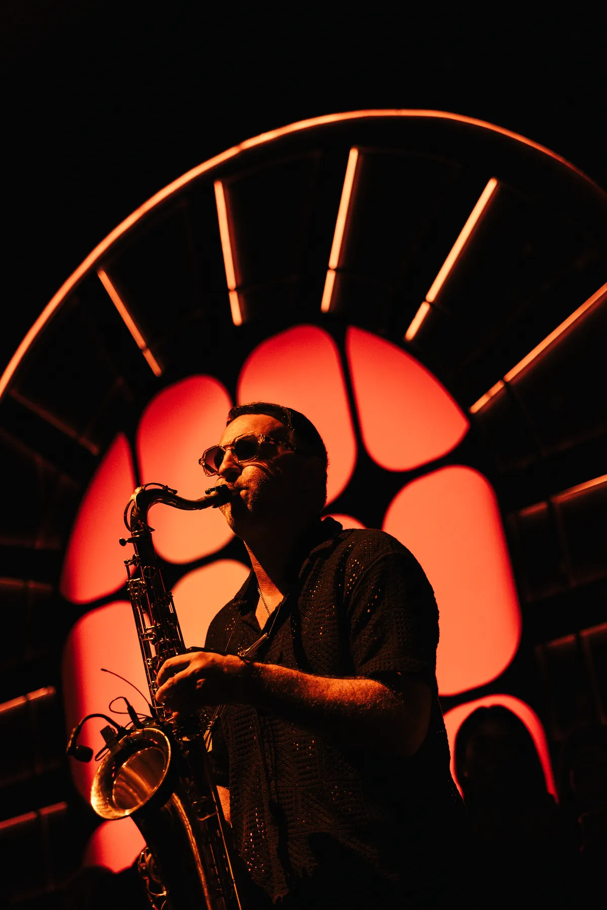 Live saxophone against the illuminated arch at MIRA