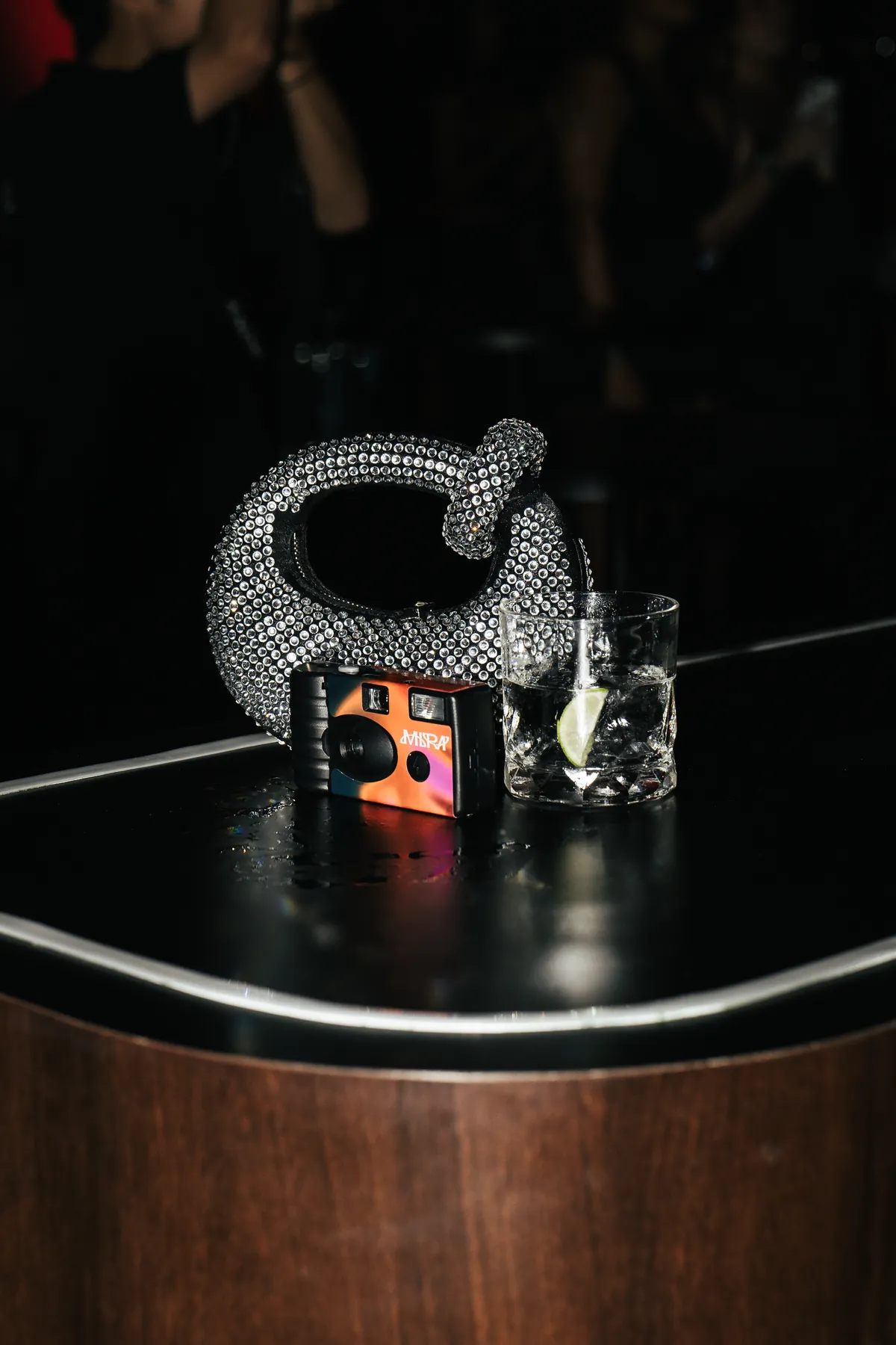 A crystal camera and cocktail on a table at MIRA