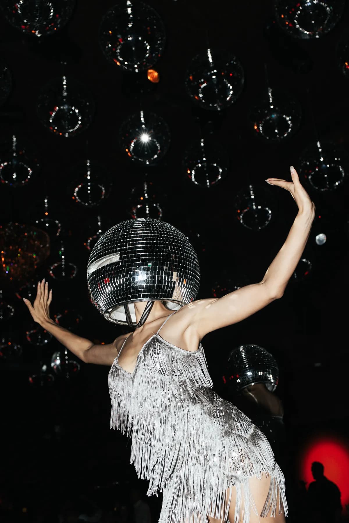 A performer under mirror balls on the MIRA dancefloor